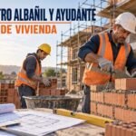 Maestro albañil y ayudante trabajando con protección en una obra de vivienda